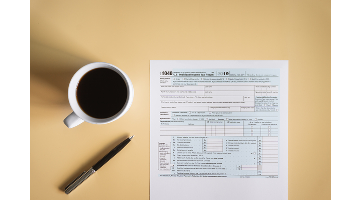 form 1040 on table with pen and coffee