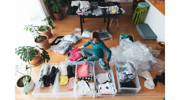 women packs away clothes for winter
