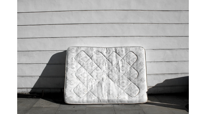 white mattress in front of garage