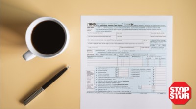 form 1040 on table with pen and coffee