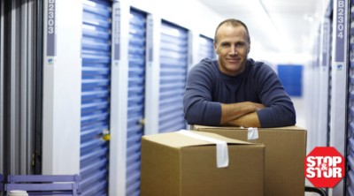 man leaning on boxes outside self storage