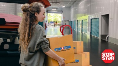 woman carrying stop and stor boxes from her car