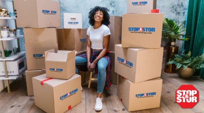 Woman preparing to pack for a small storage unit with Stop & Stor boxes