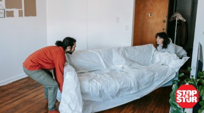 couple lifting couch to be stored in storage unit