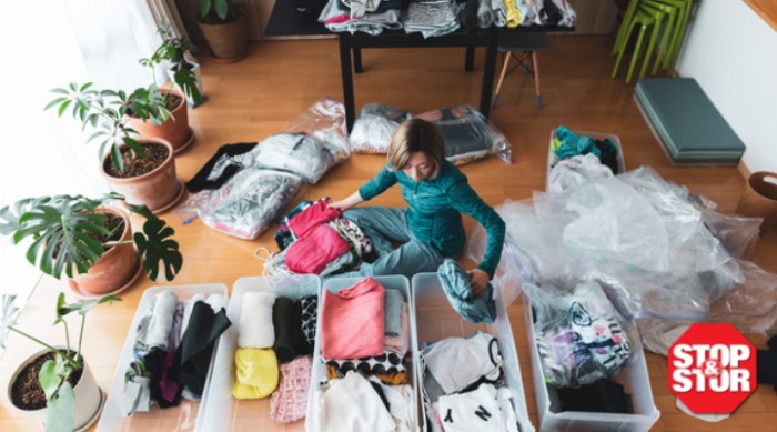 women packs away clothes for winter