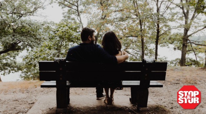 man and woman sitting on park bench