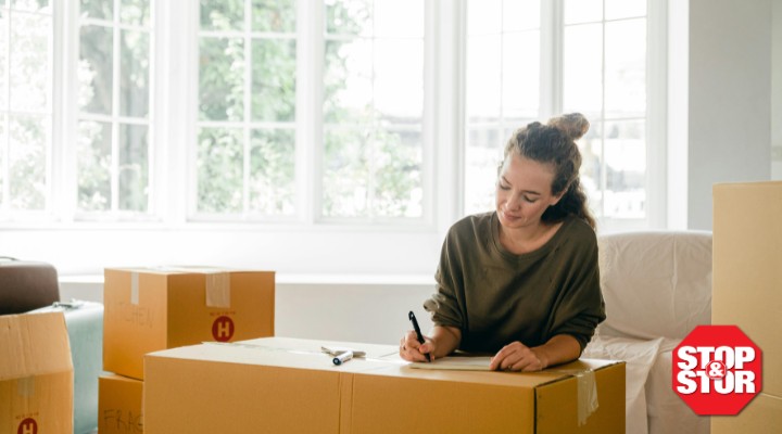 woman downsizing apartment writing on boxes
